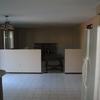 Kitchen and dining room after popcorn removed, knockdown texture applied and then primed. Ceilings and walls painted next.